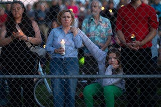 People attend a vigil at Lynnhurst Park to mourn the dead and pray for the wounded after a gunman opened fire on students at Annunciation Catholic School on 27 August 2025 in Minneapolis, Minnesota